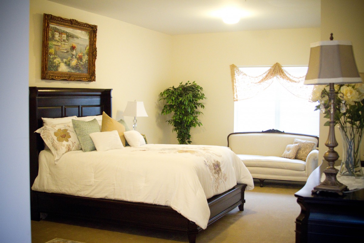 A cozy bedroom with a large bed, a couch, and decorative elements.