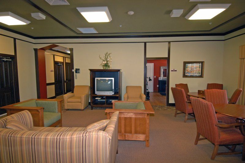 A cozy indoor seating area featuring comfortable chairs, a television, and wooden furniture.