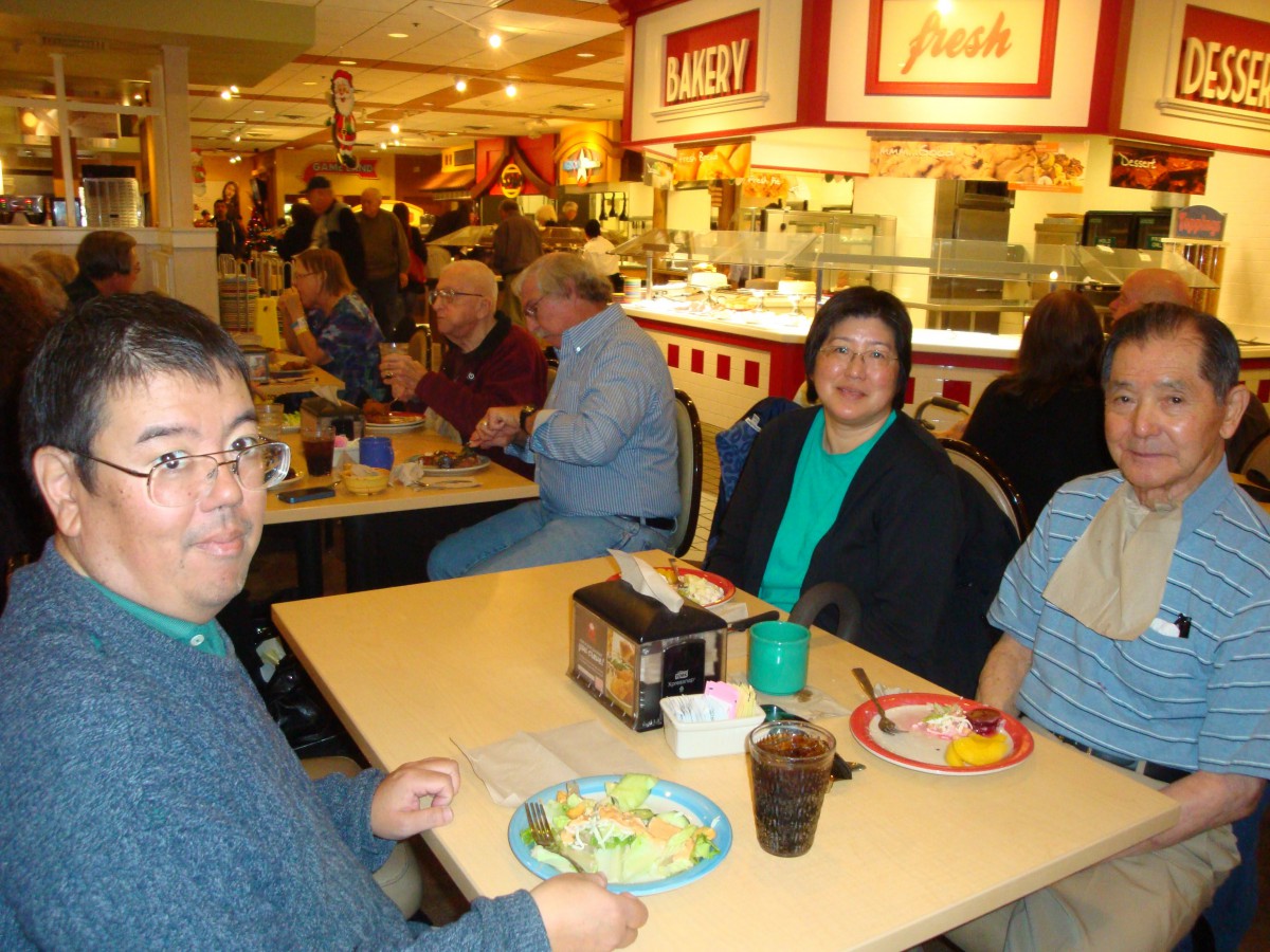A group of people enjoying a meal at a busy buffet restaurant.