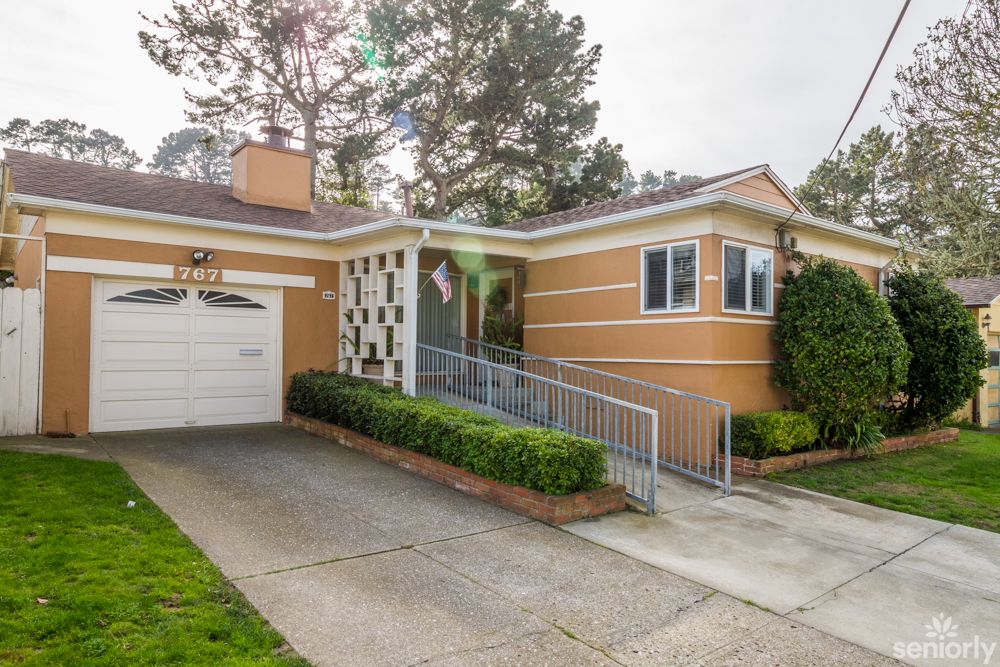 A suburban house with a garage and an accessible ramp.