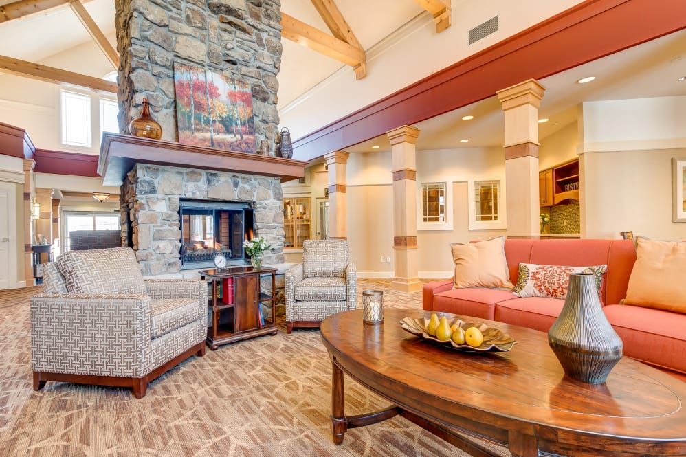 A cozy living room featuring a stone fireplace and comfortable seating.