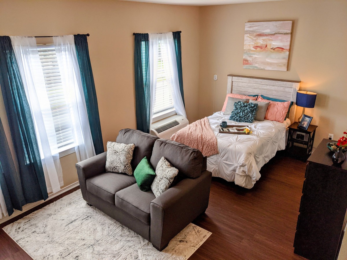 A cozy bedroom with a neatly made bed and a comfortable sofa.