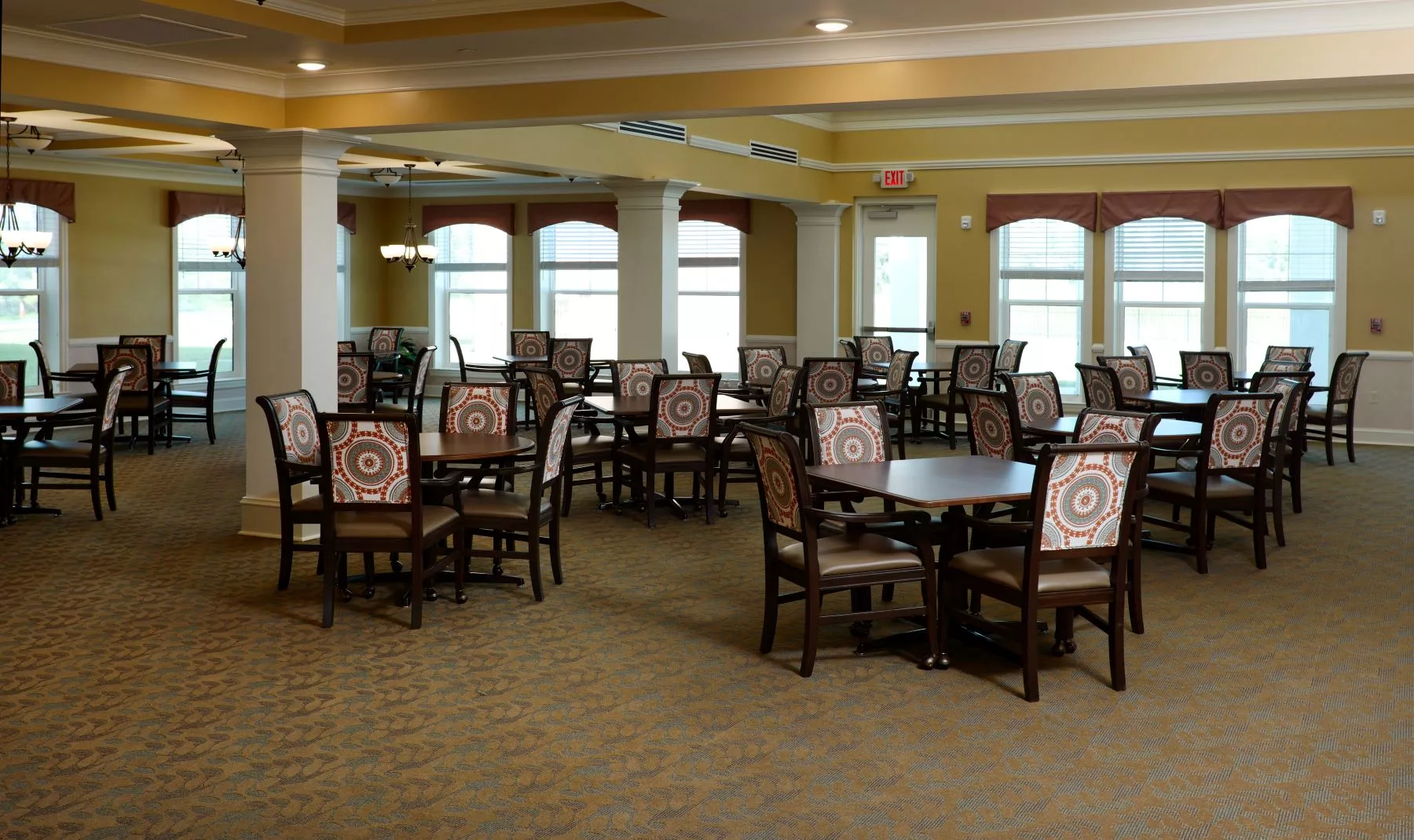 An empty dining room with neatly arranged tables and chairs.