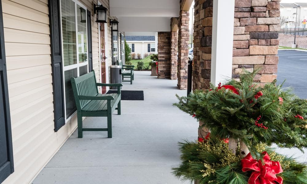 A welcoming porch with benches and seasonal decorations.