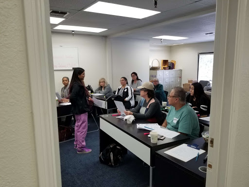 A teacher presents to a group of students in a classroom setting.