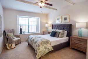 A cozy and modern bedroom featuring a large bed, stylish decor, and natural light streaming through a window.
