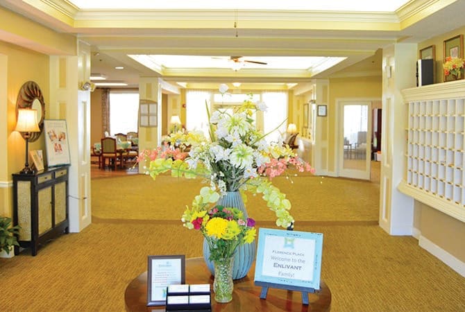A well-decorated lobby featuring a large vase of flowers on a central table.
