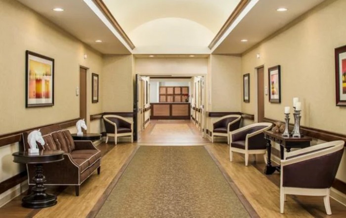 A well-lit hallway with seating options, leading to a main entrance.