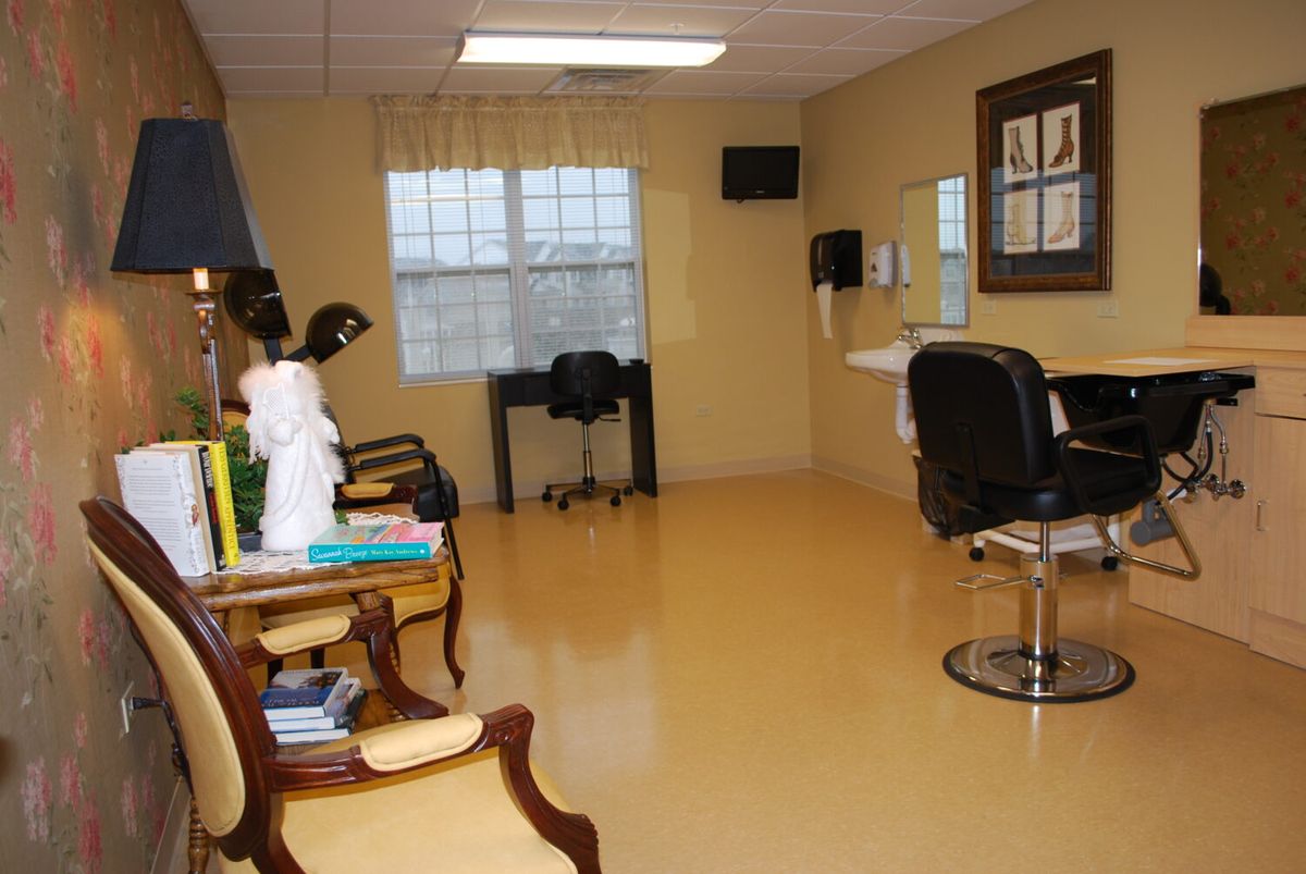 A small, well-lit salon room with a chair and styling station.