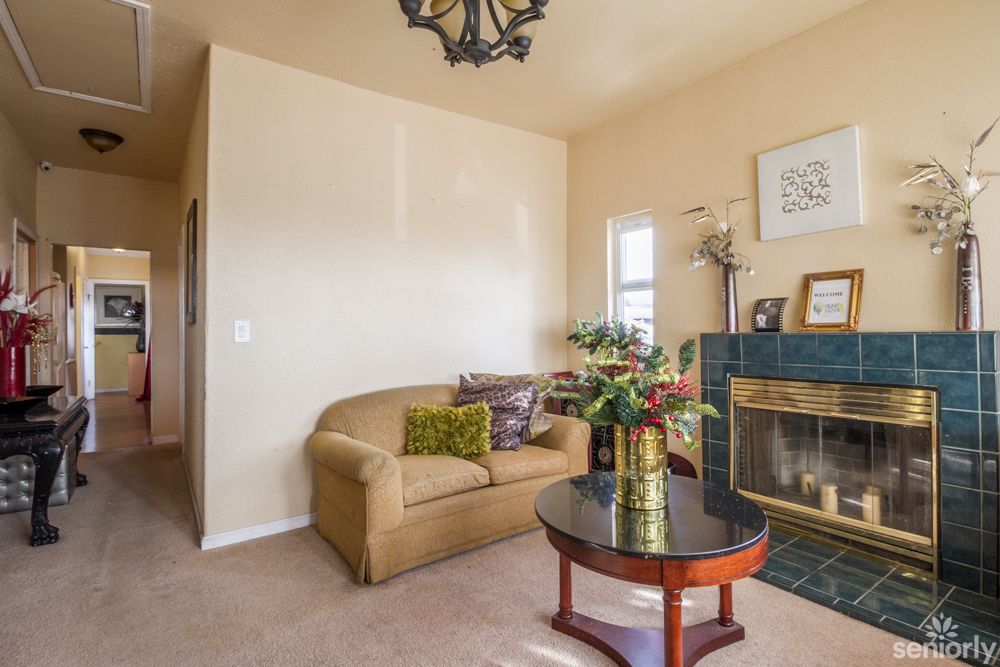 A cozy living room with a couch, coffee table, and decorative fireplace.