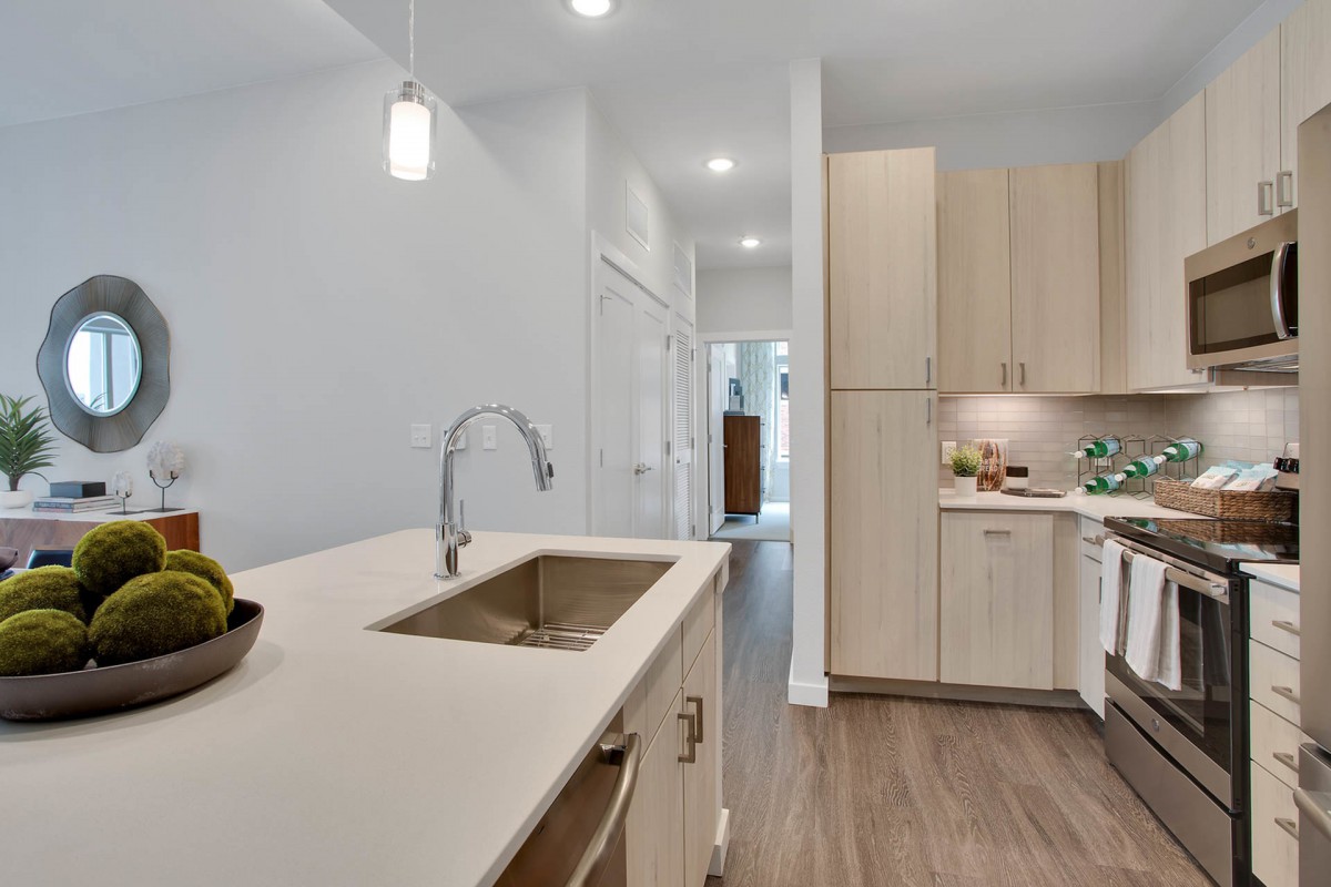 A modern, minimalist kitchen with a sleek countertop and sink.