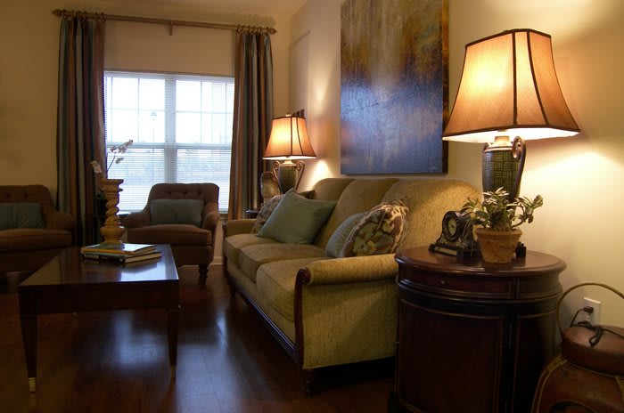 A cozy living room with a sofa, armchair, and ambient lighting.