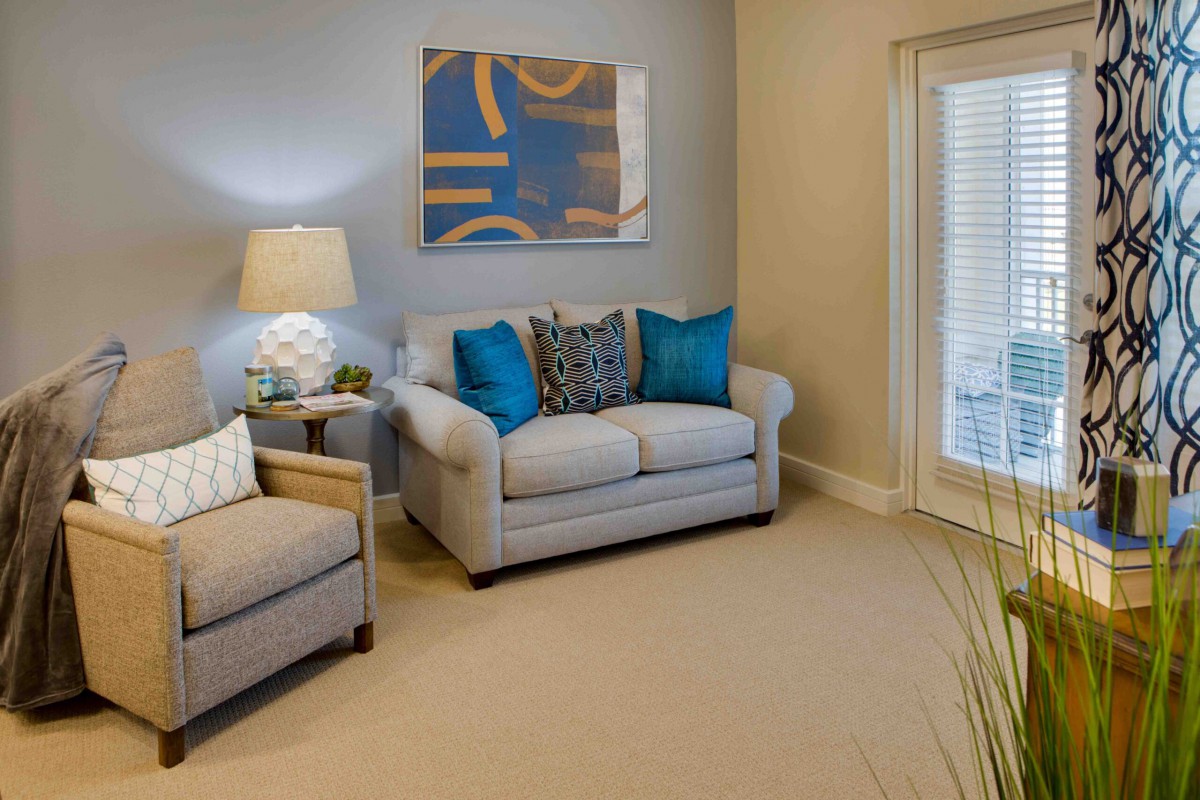 A cozy living room with a couch, armchair, and modern decor.