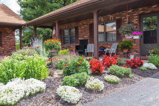 A beautifully landscaped front yard featuring vibrant flowers and cozy outdoor seating.