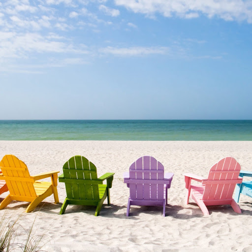 Colorful chairs lined up on a serene beach, inviting relaxation by the ocean.