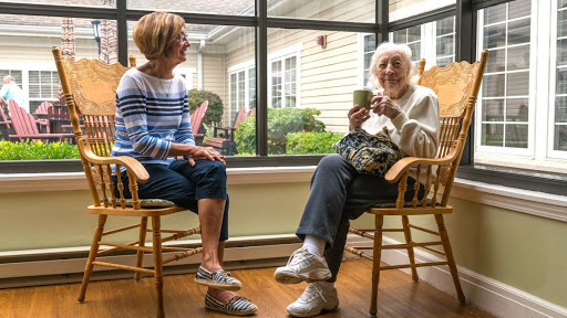 A warm conversation between two women in a sunlit room.