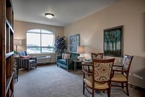 A cozy living room with stylish furniture and artwork, featuring a large window for natural light.