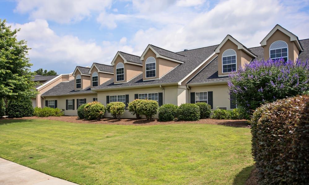 A row of suburban townhouses with a well-manicured lawn.