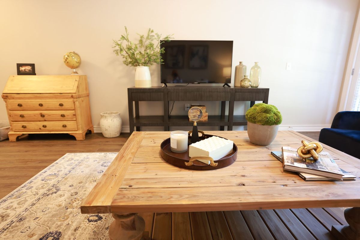A cozy living room with a wooden coffee table and modern decor.