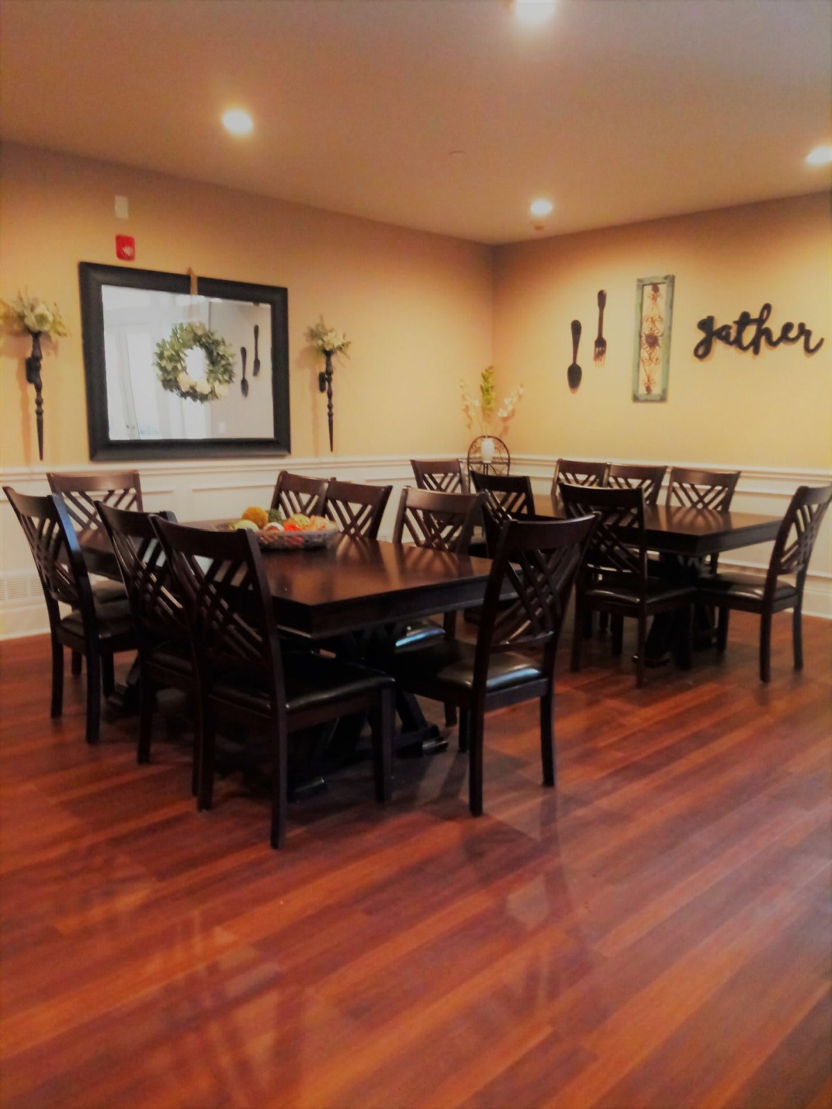 A cozy dining room with wooden tables and chairs, decorated with wall art and soft lighting.