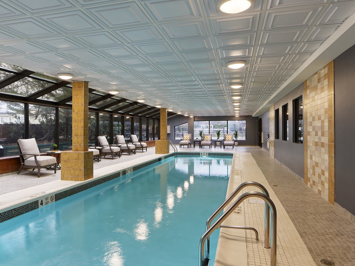 A luxurious indoor swimming pool with lounge chairs and a serene atmosphere.
