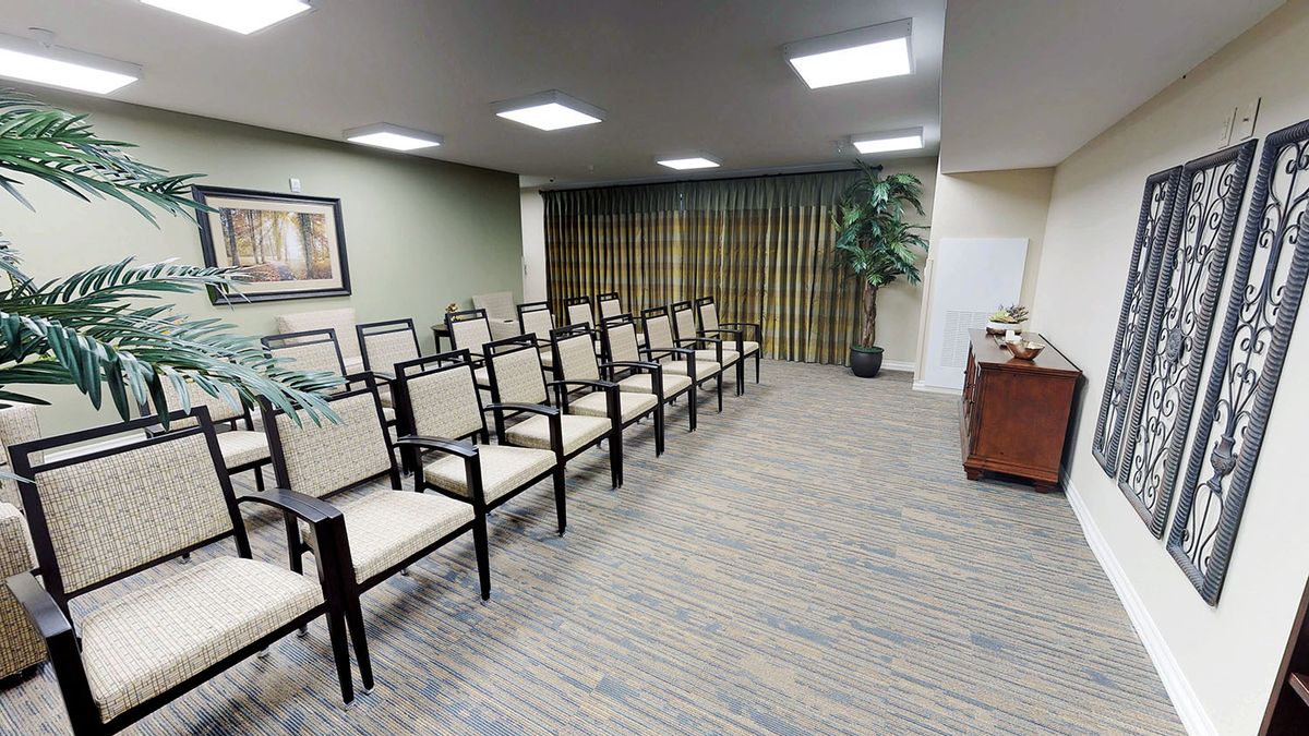 A neatly arranged conference room with rows of chairs and a presentation area.