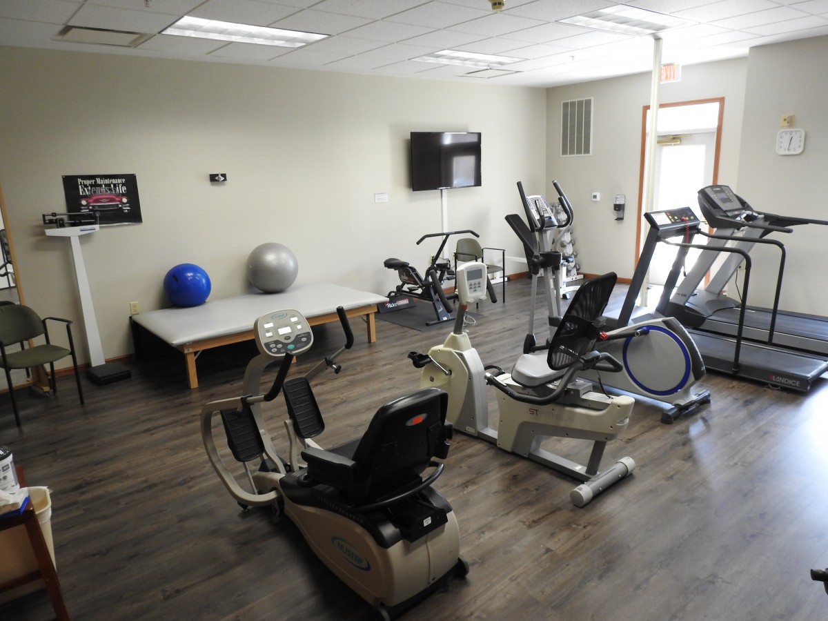 A small gym setup with various exercise machines and equipment.