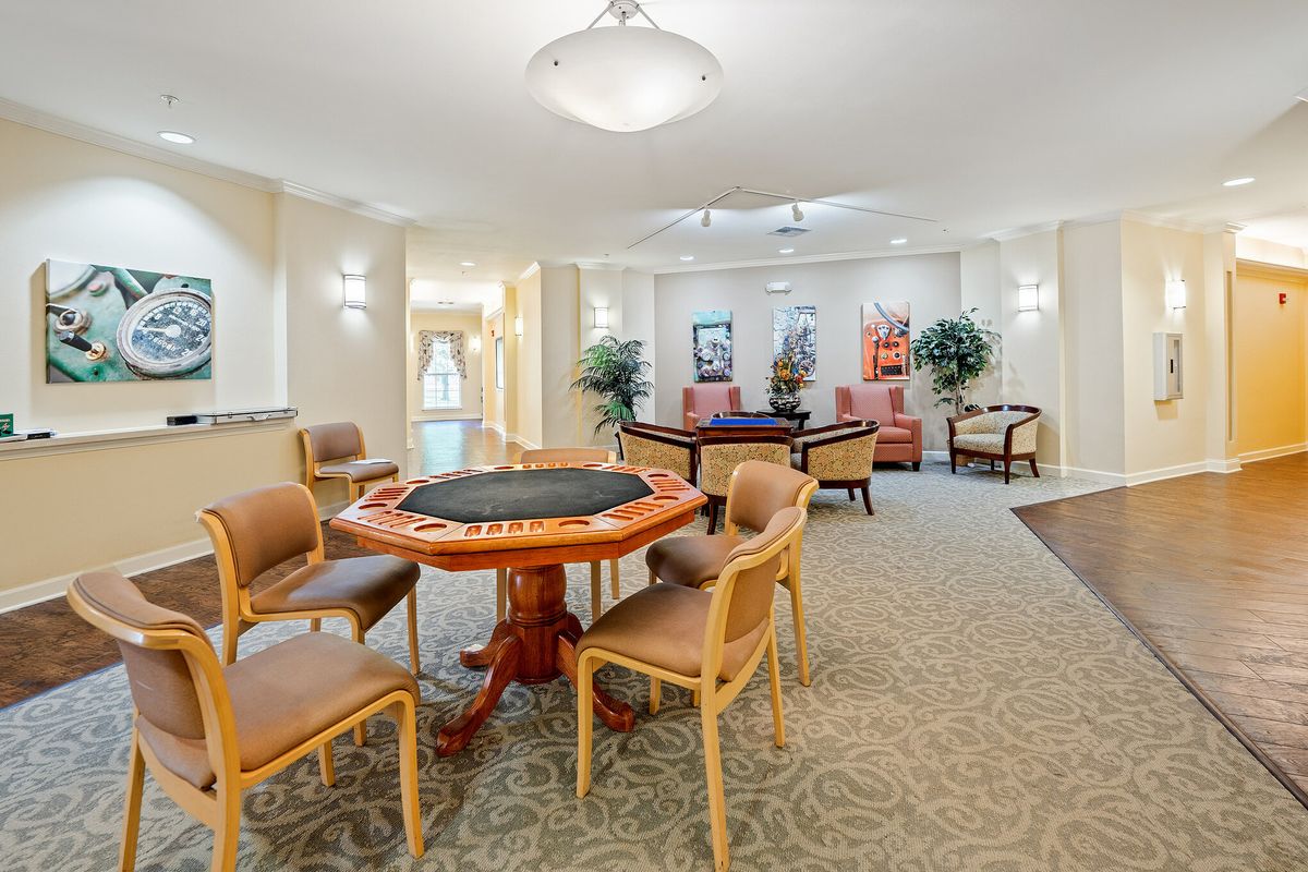 A well-lit, inviting interior space with a dining table and chairs arranged for communal activities.