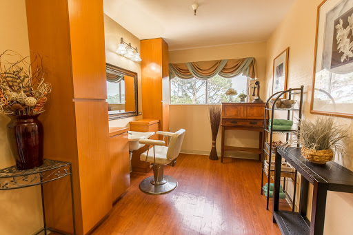 A stylish and well-lit vanity area featuring a comfortable chair, perfect for makeup application.