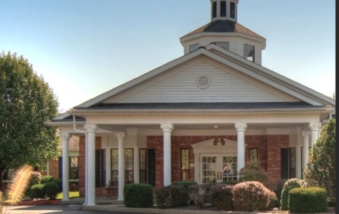 A traditional brick building with a columned entrance and cupola.