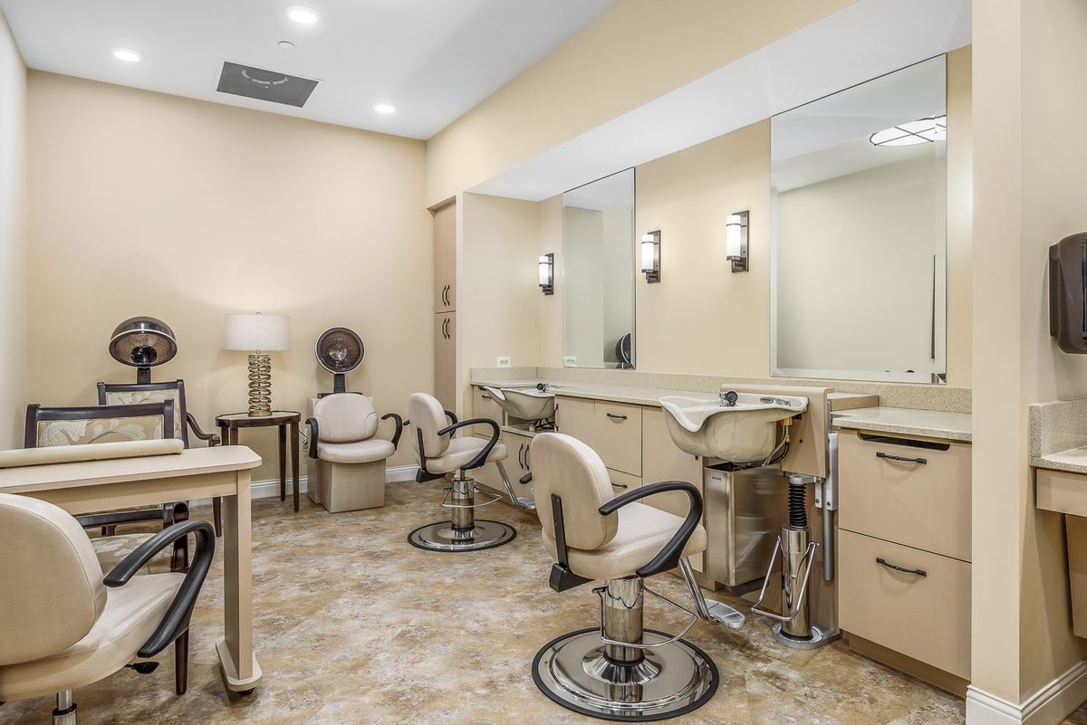 A well-lit beauty salon with styling chairs and mirrors.