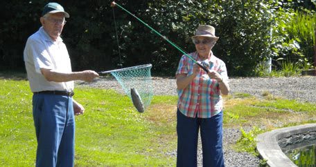 A person outdoors engaged in fishing, holding a net with a fish.
