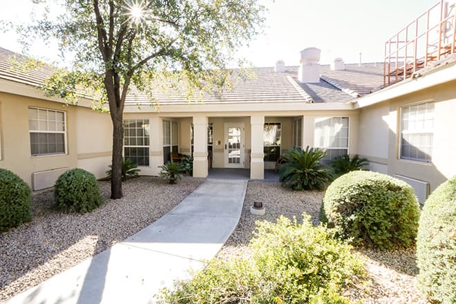 A welcoming entrance to a single-story house with a landscaped front yard and pathway.