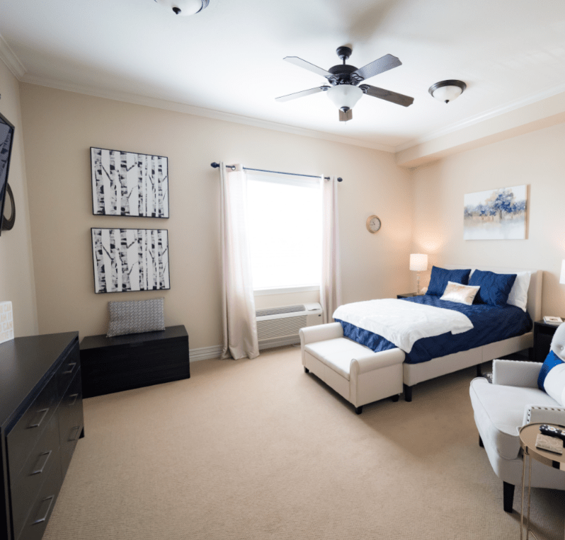 A modern, well-decorated bedroom with a cozy bed and natural light.