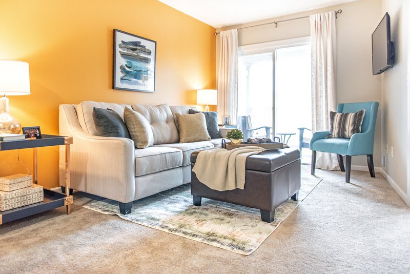 A cozy and stylish living room with a beige sofa, vibrant yellow walls, and elegant decor.