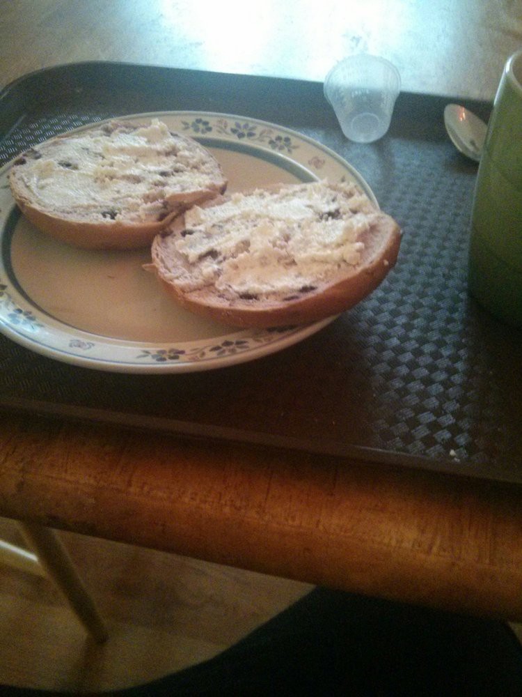 A bagel with cream cheese served on a plate.