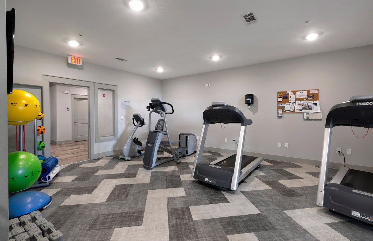 A small gym with fitness equipment, including a treadmill and exercise bike.