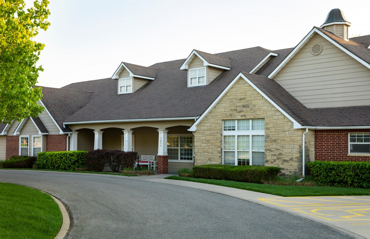 A large residential house with a driveway and well-maintained front yard.