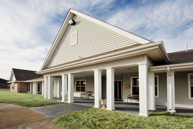 A residential building with a porch supported by white columns.