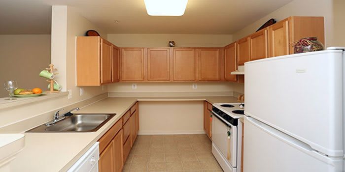 A compact kitchen with wooden cabinets and basic appliances.