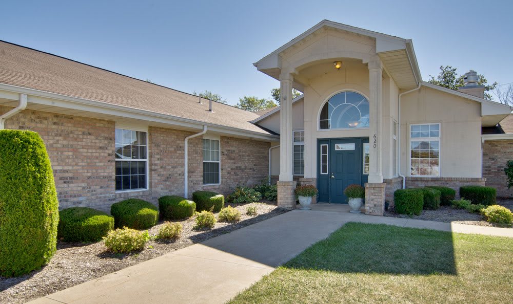 A well-maintained house with a grand entrance and manicured landscaping.