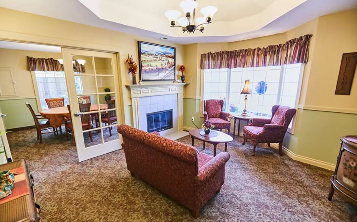 A cozy living room with a fireplace and seating area.