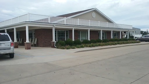 A welcoming residential building with a porch and landscaped surroundings.