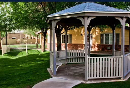 A charming gazebo surrounded by lush greenery, providing a peaceful retreat in the garden.