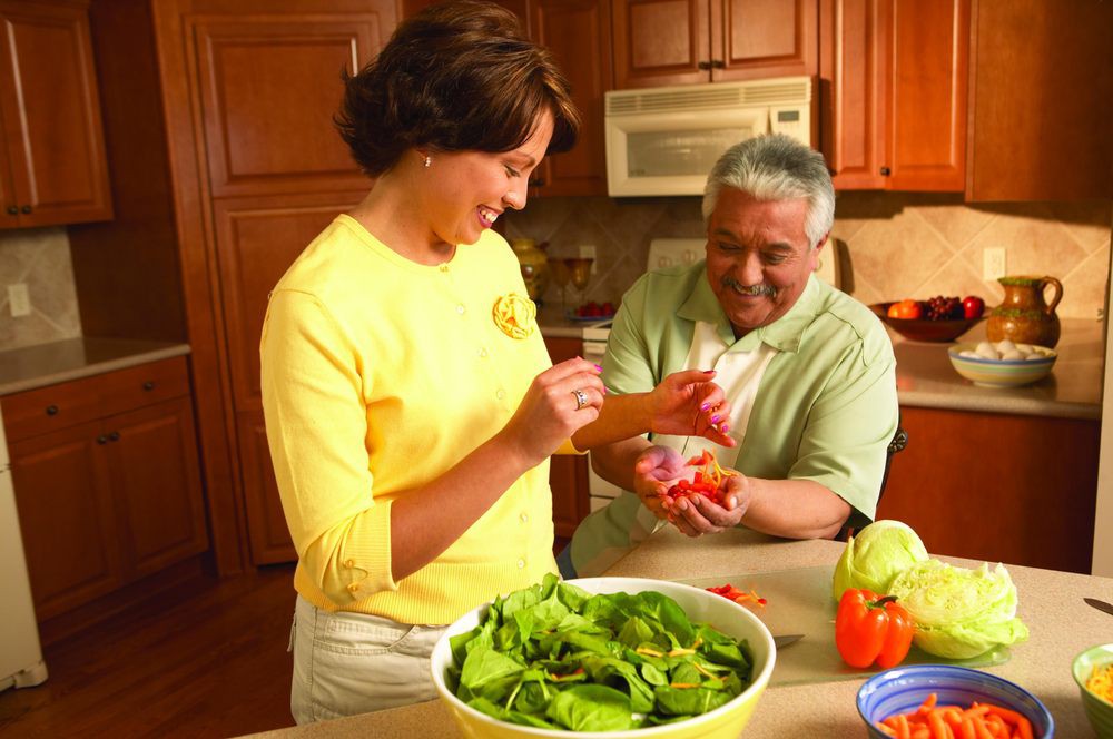 A couple preparing a fresh salad together in the kitchen.