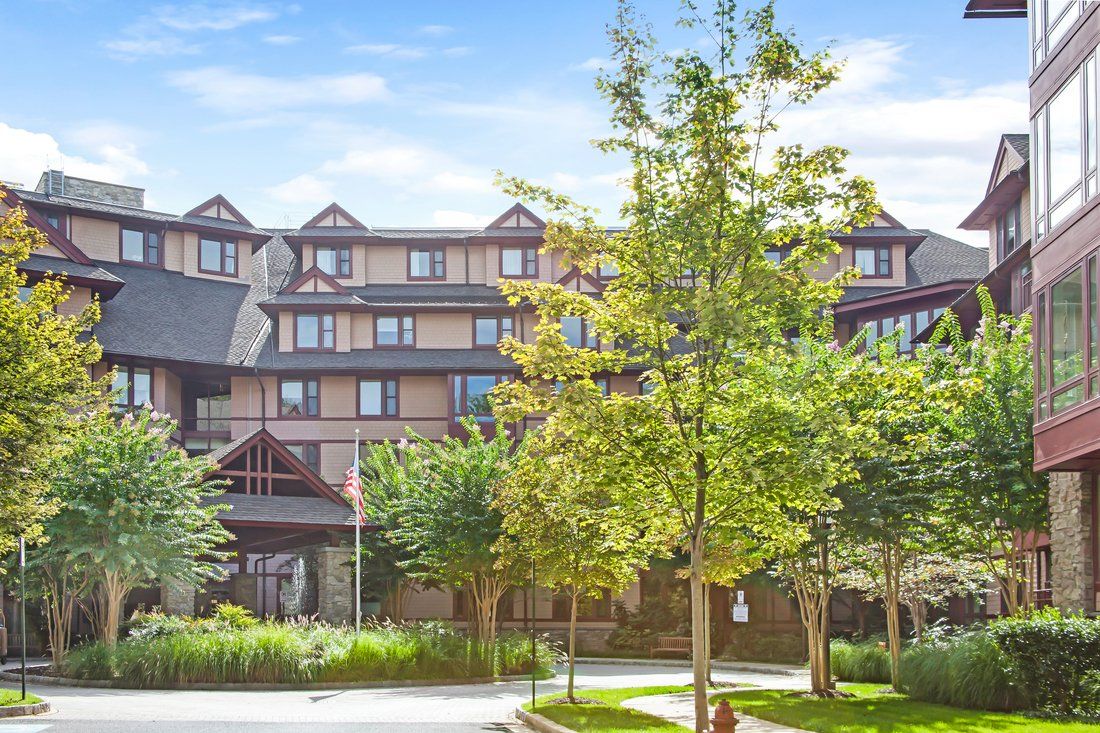 A hotel building surrounded by lush greenery and trees.