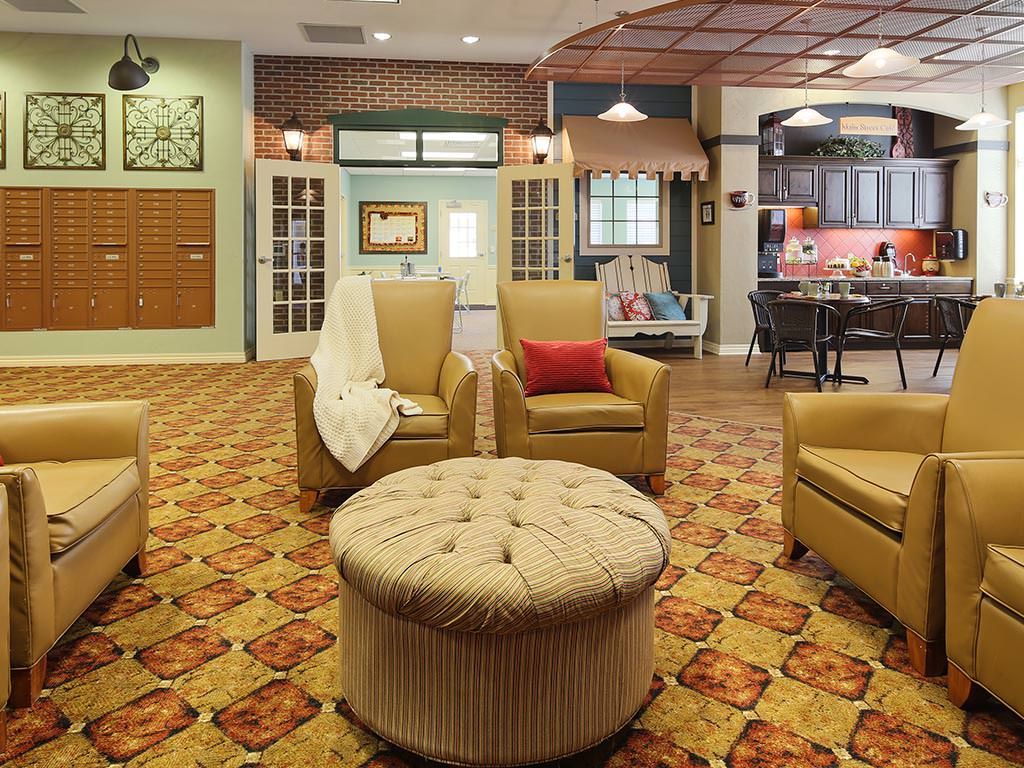 A cozy living room featuring a seating area with several armchairs, an ottoman, and warm decorative elements.