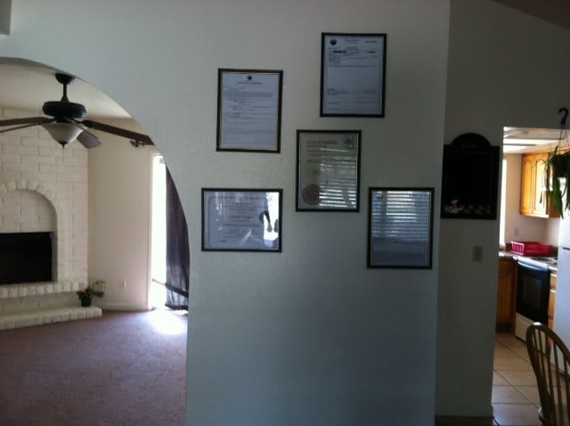 Framed certificates displayed on an interior wall.