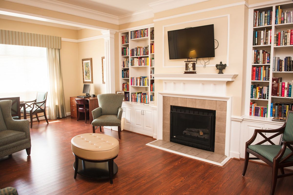 A cozy living room with a fireplace, television, and bookshelf.