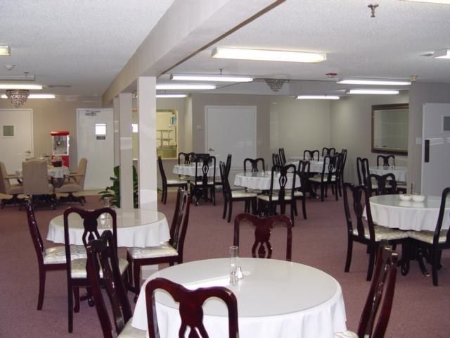 An empty dining room with round tables and chairs arranged neatly.